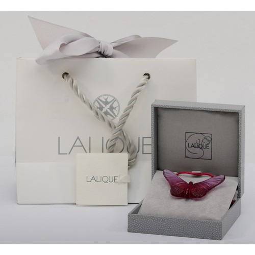 275 - Lalique, a pink glass butterfly pendant on silk cord, 58 x 33mm, original box and bag.