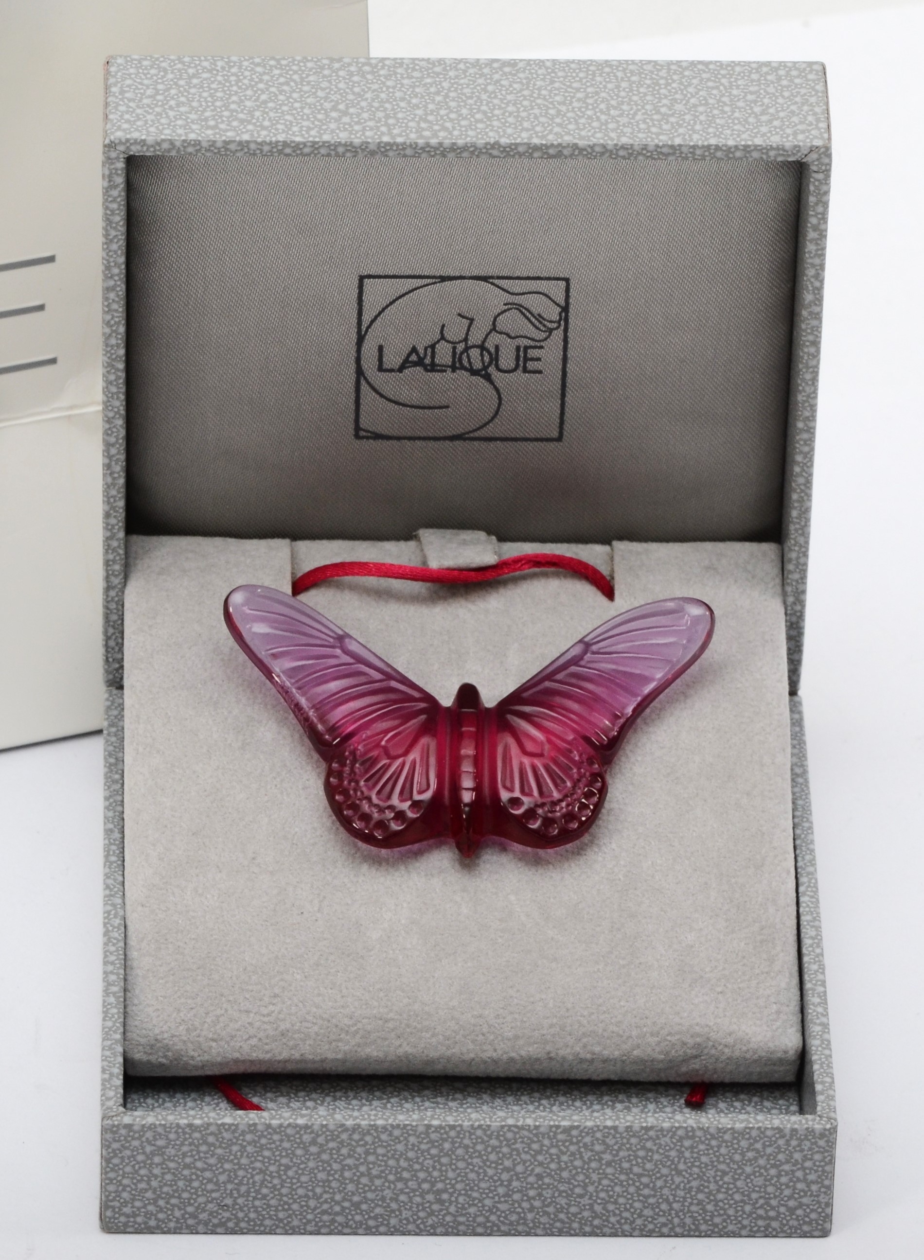 Lalique, a pink glass butterfly pendant on silk cord, 58 x 33mm ...