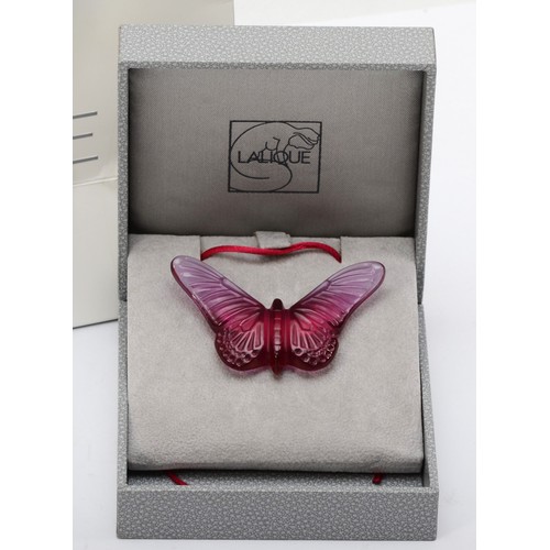 275 - Lalique, a pink glass butterfly pendant on silk cord, 58 x 33mm, original box and bag.