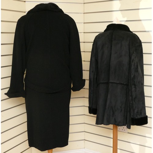 278 - A black long length button up wool coat with a faux fur collar, flap over concealed pockets, size 16... 