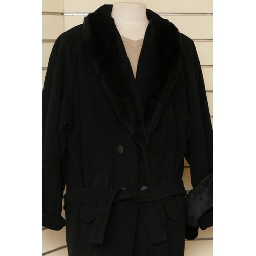 278 - A black long length button up wool coat with a faux fur collar, flap over concealed pockets, size 16... 