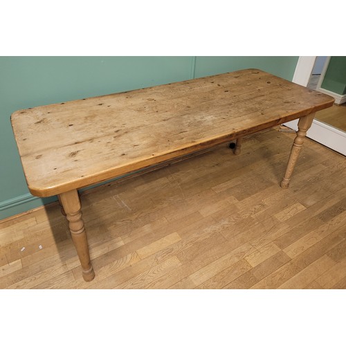 306 - A traditional waxed pine dining or kitchen table, rectangular top, raised on turned tapering support... 