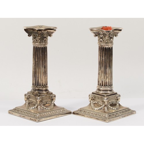 64 - An Edwardian silver pair of Corinthian column candlesticks, London 1903, with acanthus leaf capitals... 