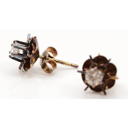 111 - A pair of unmarked gold brilliant cut diamond single stone floral stud earrings, stamped 9ct to butt... 