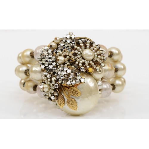 A Miriam Haskell three strand faux baroque pearl and foil backed rhinestone floral bracelet, c.1950,  signed to the reverse, 55mm.