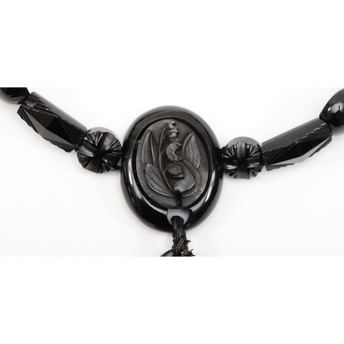 127 - A Victorian Whitby jet and silver clasped necklace, with carved floral pendant and spacers, 44cm, re... 