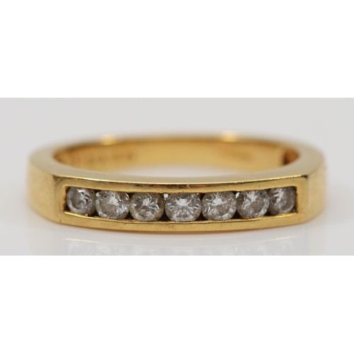 137 - An 18ct gold brilliant cut channel set diamond half eternity ring, M, 3.4gm.