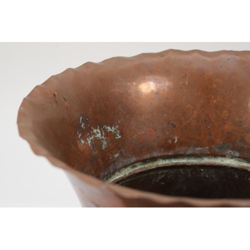 230 - An early 20th century hammered copper waisted cache pot/jardinière, with crimped rim and stylised fl... 