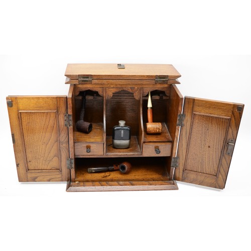 238 - An Arts and Crafts oak and hammered copper twin door smokers cabinet, the panels decorated with styl... 