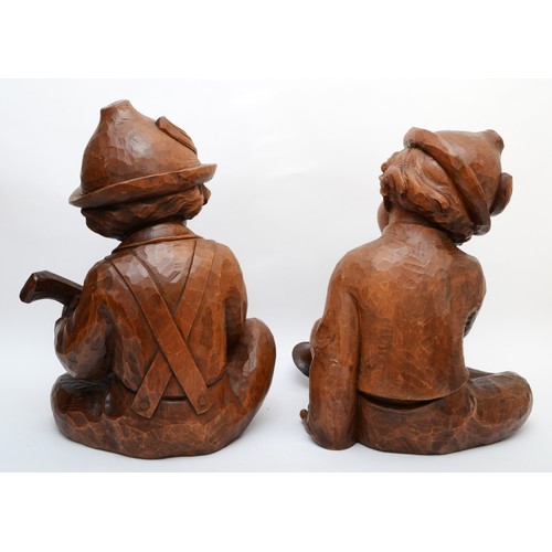 244 - A rare pair of carved wood Hummel figures, presumed ex shop display, of seated boys playing musical ... 