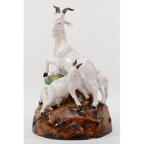 261 - A richly painted and glazed porcelain figural group of four goats raised on naturalistic base, unsig... 