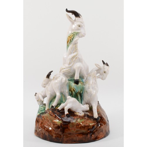 261 - A richly painted and glazed porcelain figural group of four goats raised on naturalistic base, unsig... 