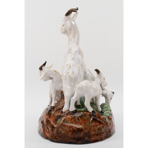 261 - A richly painted and glazed porcelain figural group of four goats raised on naturalistic base, unsig... 