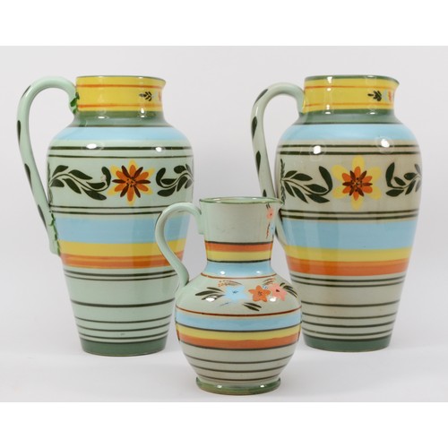 275 - Castleford Pottery; three 20th century painted and glazed jugs decorated in the Peasant pattern, 27c... 