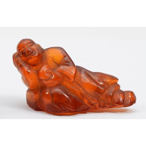 281 - Three Chinese 20th century carved amber figures comprising of two fisherman, 5.3cm high, a standing ... 