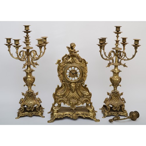 303 - A 20th century gilt brass three piece clock garniture, the clock case cast with head of Bacchus surm... 