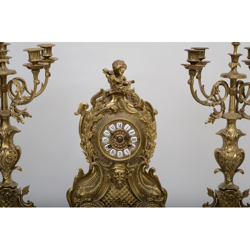 303 - A 20th century gilt brass three piece clock garniture, the clock case cast with head of Bacchus surm... 