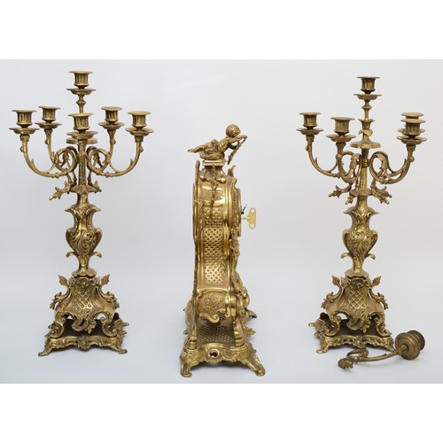 303 - A 20th century gilt brass three piece clock garniture, the clock case cast with head of Bacchus surm... 