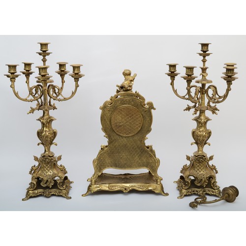 303 - A 20th century gilt brass three piece clock garniture, the clock case cast with head of Bacchus surm... 