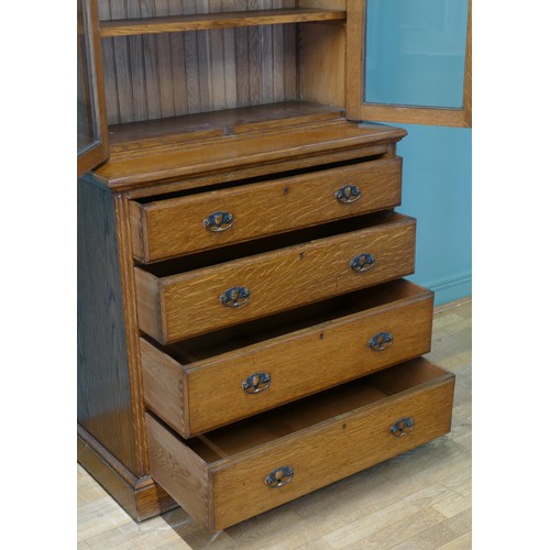 383 - An Edwardian oak twin door glazed bookcase, opening to reveal adjustable shelves above a chest of fo... 