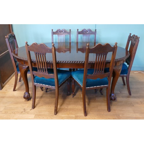 384 - An early 20th century mahogany wind out extending dining table with carved moulding, raised on cabri... 