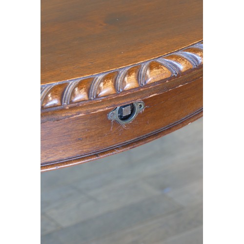 384 - An early 20th century mahogany wind out extending dining table with carved moulding, raised on cabri... 