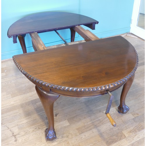 384 - An early 20th century mahogany wind out extending dining table with carved moulding, raised on cabri... 