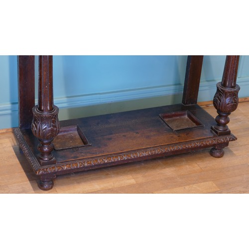 389 - A late 19th century heavily carved oak mirror back hallstand/coat stand, the frieze carved with the ... 