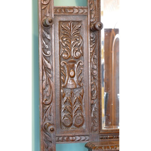 389 - A late 19th century heavily carved oak mirror back hallstand/coat stand, the frieze carved with the ... 