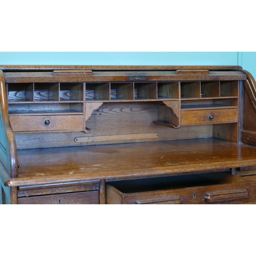 391 - An early 20th century oak tambour twin pedestal writing desk, opening to reveal fitted interior, eac... 