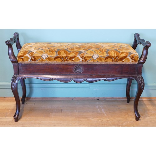 392 - An early 20th century mahogany duet piano stool with shaped and carved supports, upholstered box sea... 