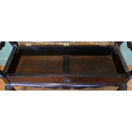 392 - An early 20th century mahogany duet piano stool with shaped and carved supports, upholstered box sea... 