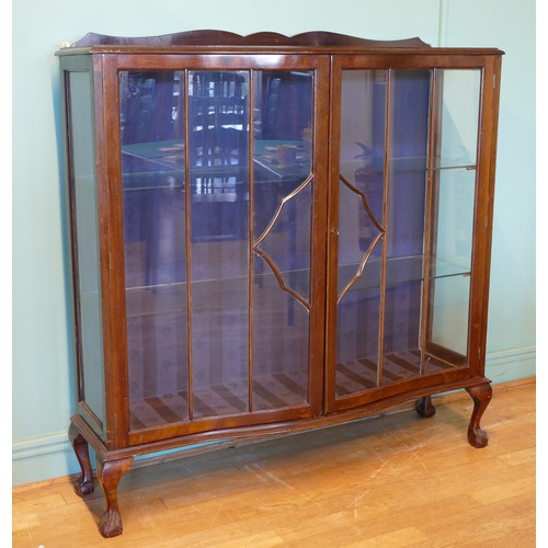 393 - An Edwardian mahogany display cabinet, having two glazed doors of serpentine form opening to reveal ... 