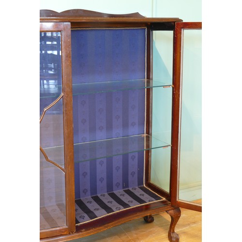 393 - An Edwardian mahogany display cabinet, having two glazed doors of serpentine form opening to reveal ... 