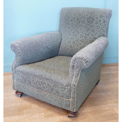 394 - An early 20th century Howard style deep seated armchair, upholstered in a green floral fabric, horse... 