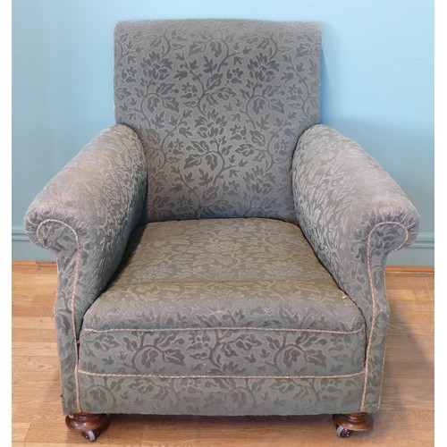 394 - An early 20th century Howard style deep seated armchair, upholstered in a green floral fabric, horse... 