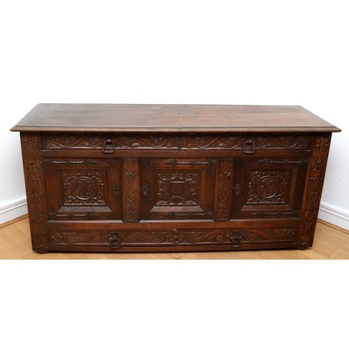 398 - A 19th century heavily carved oak cabinet, with two drawers above three cupboard doors, the central ... 