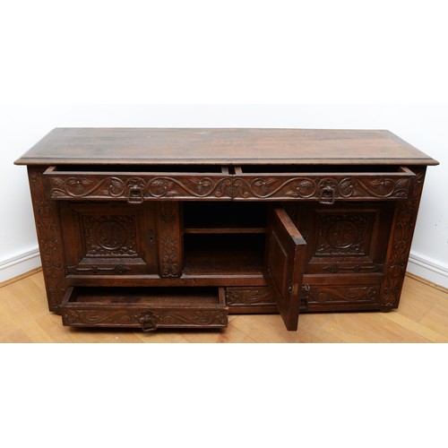 398 - A 19th century heavily carved oak cabinet, with two drawers above three cupboard doors, the central ... 