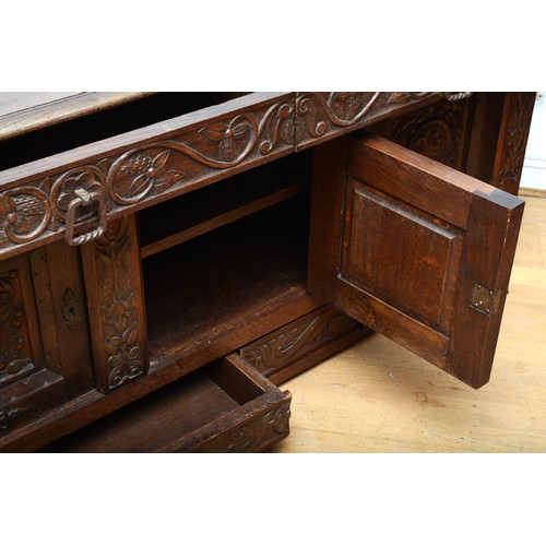 398 - A 19th century heavily carved oak cabinet, with two drawers above three cupboard doors, the central ... 