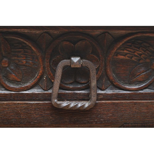 398 - A 19th century heavily carved oak cabinet, with two drawers above three cupboard doors, the central ... 