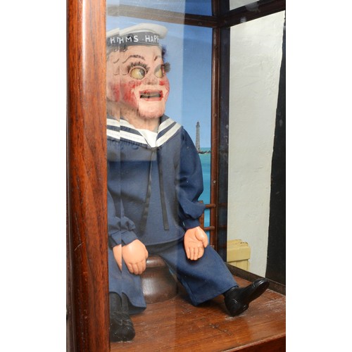 424 - Laughing sailor, HMS Happy, by Modern Enterprises, stained oak cabinet, raised on cast metal feet, 5... 