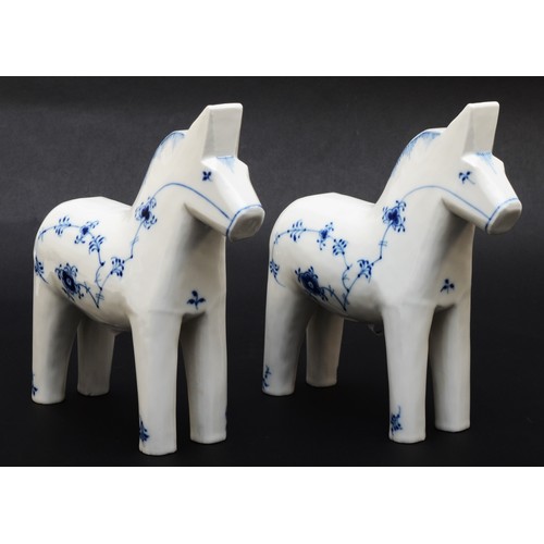 268 - Royal Copenhagen'; a pair of 'Blue Fluted Plain' painted porcelain standing Dala horses, each with m...