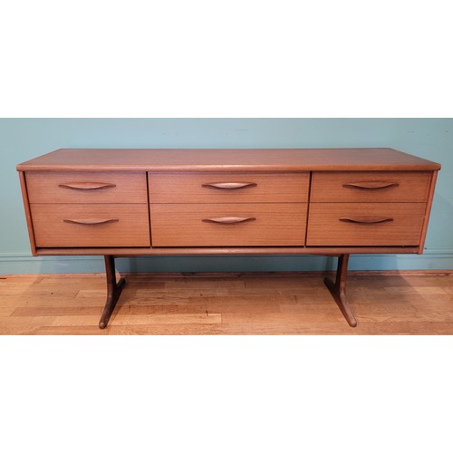 A mid 20th century Austinsuite teak six drawer sideboard, raised on stylised trestle supports, gold painted mark to inside of a drawer, 154cm wide