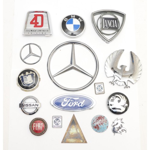 121 - A collection of car badges, including Lancia and Fiat, together with a Ford 4D tractor badge