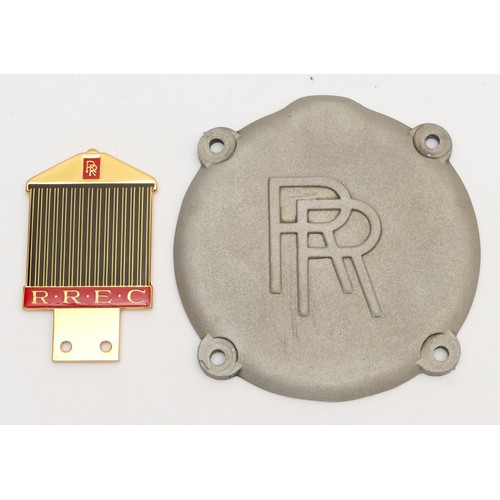 122 - A gold plated and enamel RREC grill badge and an alloy RR cover plate, part no G50143 (2)