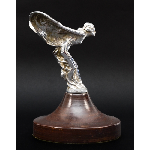 A Rolls Royce Spirit of Ecstasy mascot, probably Phantom I or II, signed Charles Sykes to the left and Rolls Royce Ltd, Feb 6 1911 to the right, REG US PAT OFF  under left wing, TRADE MARK REG under the right wing, 15cm, mounted on a turned mahogany plinth, 20.5cm overall.