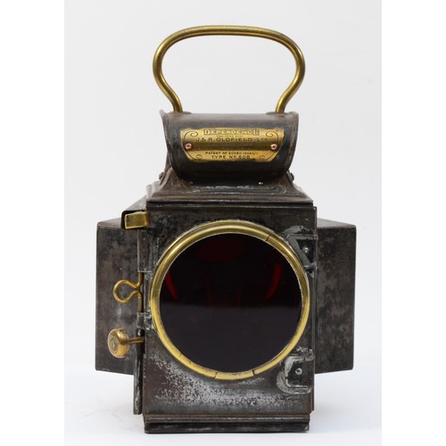 A Dependence rear lamp by J & R Oldfield, type 506, steel body with brass mounts, ruby lens, clear side lens, rear flange mount, door opens to sprung reservoir with ceramic wick holder, 24cm.