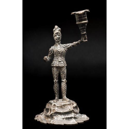 A Victorian cast silver figural candlestick, by C.T Fox & G Fox, London 1865, modelled as an armoured knight holding aloft in his left hand an urn, his left hand lacking a sword or spear, raised on a rocky outcrop 15cm, 151gm.