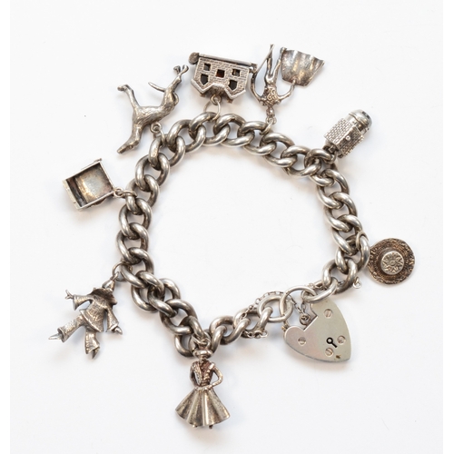 210 - A silver heart padlock clasp charm bracelet, with charms to include a gray hound, 65gm.