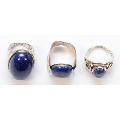 217 - Three Modernist lapis lazuli rings to include a over sized cabochon example,  K-L, 38gm.